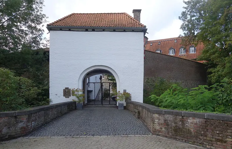 Weißes Torhaus mit Steinbrücke über den Burggraben in Düsseldorf-Angermund