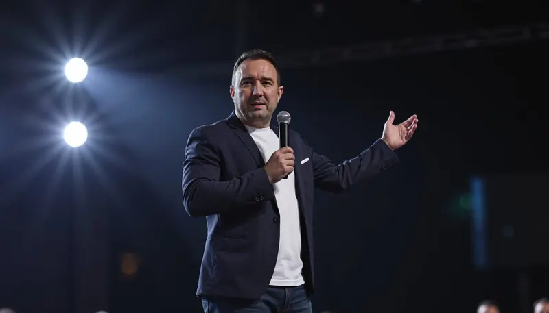 Christian Gottschling mit Mikrofon auf der Bühne bei einem Vortrag über Immobilien