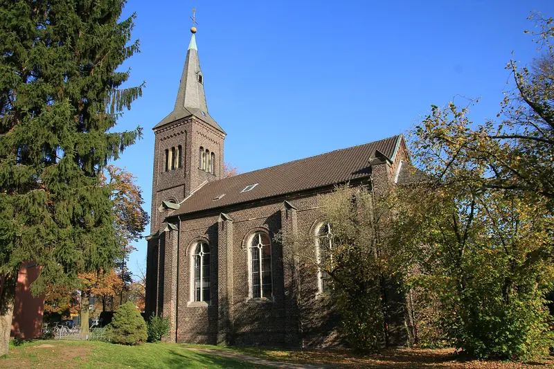 Evangelische Kirche mit spitzem Kirchturm im Grünen in Ratingen-Lintorf