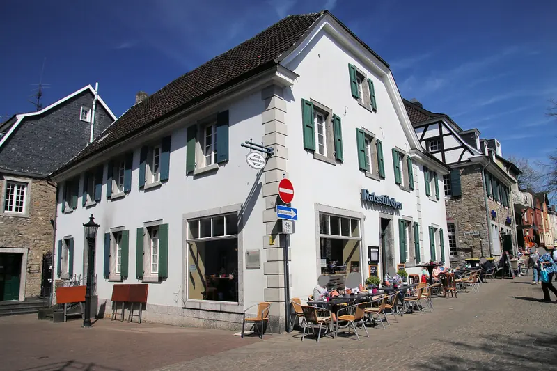 Weißes Altstadthaus mit grünen Fensterläden am Marktplatz in Ratingen-Mitte