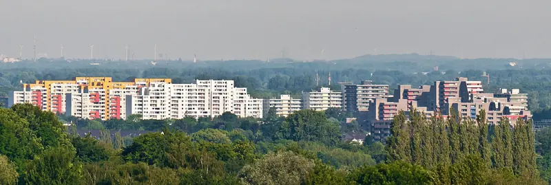 Blick über Bäume auf die markanten Wohnhochhäuser von Ratingen-West